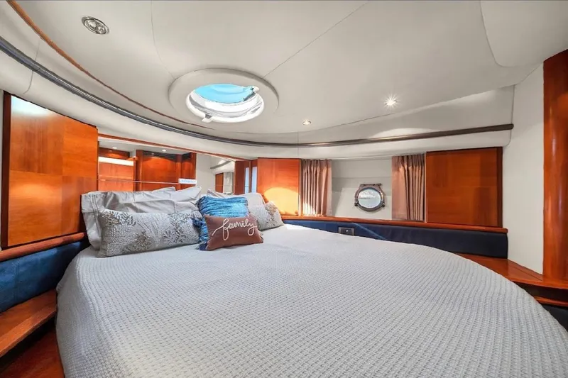  Yacht Photos Pics Luxurious bedroom interior of 2005 Azimut 50 yacht with elegant wood finishes and cozy bedding.