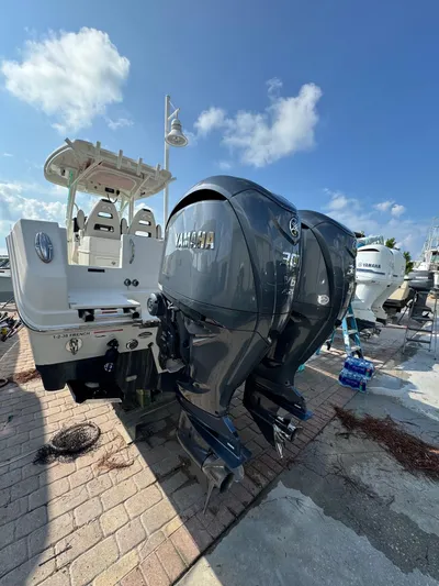  Yacht Photos Pics 2023 Sailfish 290cc boat with dual Yamaha outboard engines docked under blue sky.