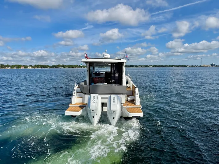  Yacht Photos Pics 2024 Beneteau Antares 11 cruising on open water under a partly cloudy sky.