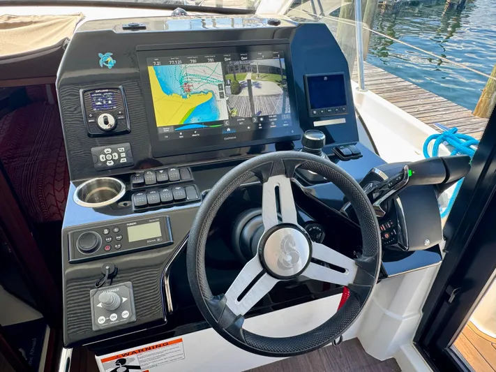  Yacht Photos Pics 2024 Beneteau Antares 11 helm with advanced navigation system and controls, dockside view.