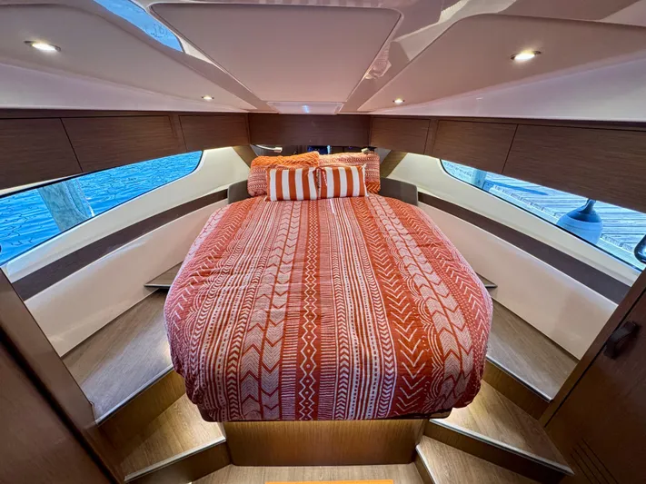  Yacht Photos Pics 2024 Beneteau Antares 11 cabin with cozy bed and stylish red bedding.