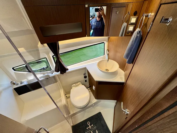 Yacht Photos Pics 2024 Beneteau Antares 11 bathroom with modern fixtures and wood accents.
