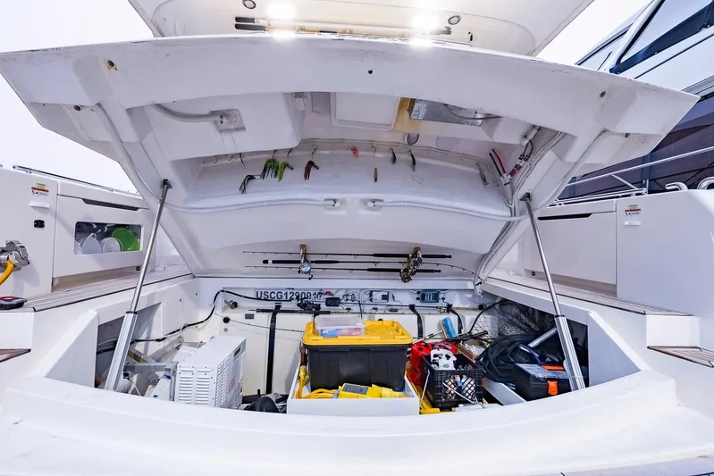  Yacht Photos Pics Open storage compartment of 2017 Maritimo M 51 yacht, showcasing fishing gear and equipment.