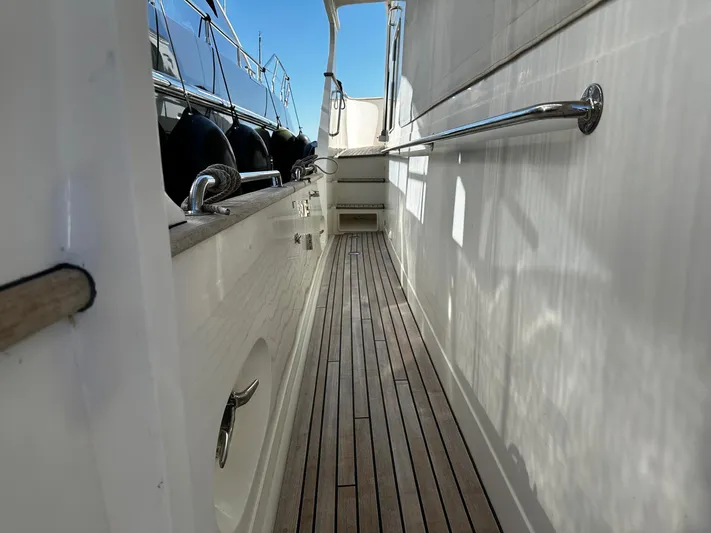 Smaragd Yacht Photos Pics Side deck of a 2003 Fleming 55 yacht with wooden flooring and metal railings.