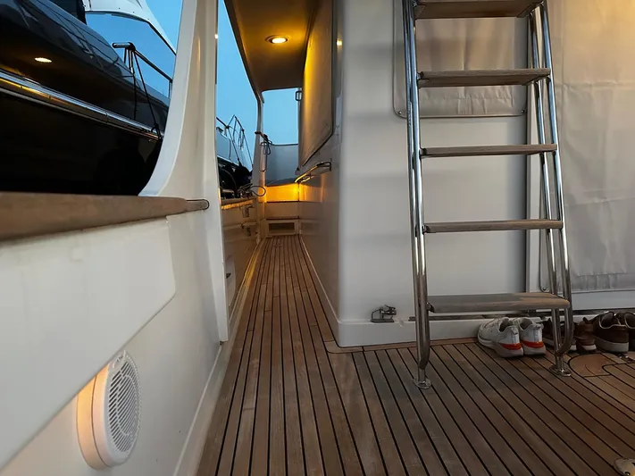 Smaragd Yacht Photos Pics 2003 Fleming 55 yacht deck with wooden flooring, metal ladder, and ambient lighting.