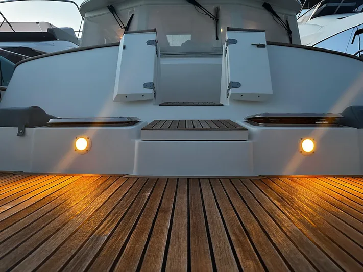 Smaragd Yacht Photos Pics Stern view of 2003 Fleming 55 yacht with illuminated deck and open doors.