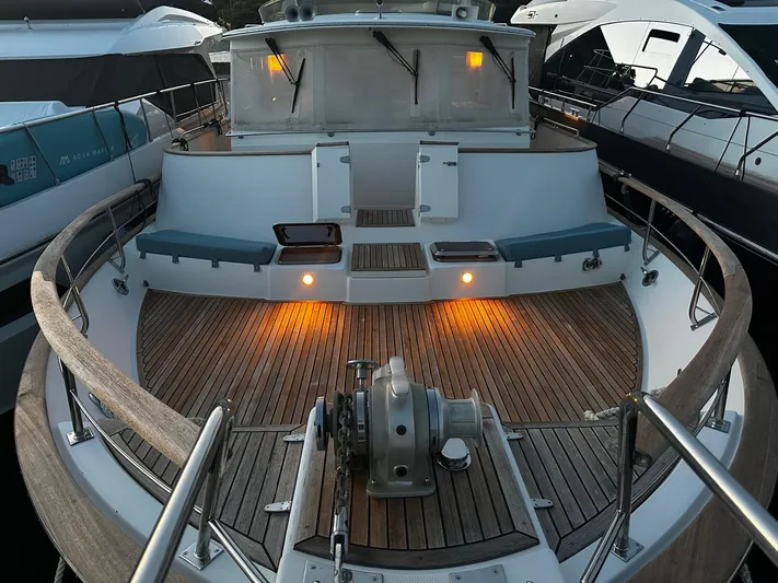 Smaragd Yacht Photos Pics 2003 Fleming 55 yacht with wooden deck and seating, docked between other boats.