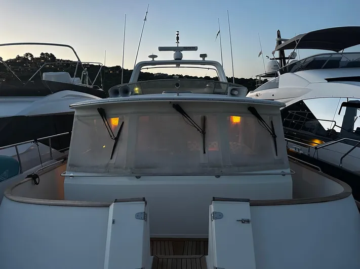 Smaragd Yacht Photos Pics 2003 Fleming 55 yacht docked at sunset, featuring a sleek design and illuminated interior.