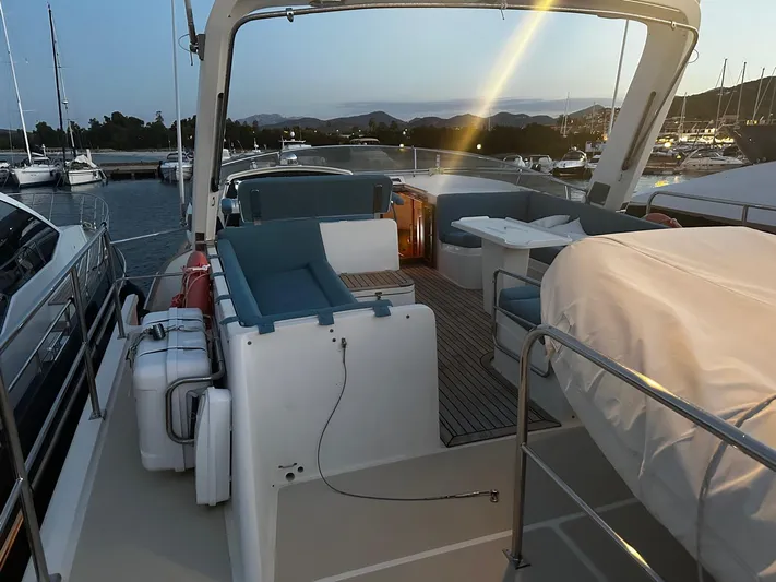 Smaragd Yacht Photos Pics Luxurious 2003 Fleming 55 yacht deck at sunset, featuring comfortable seating and scenic marina views.