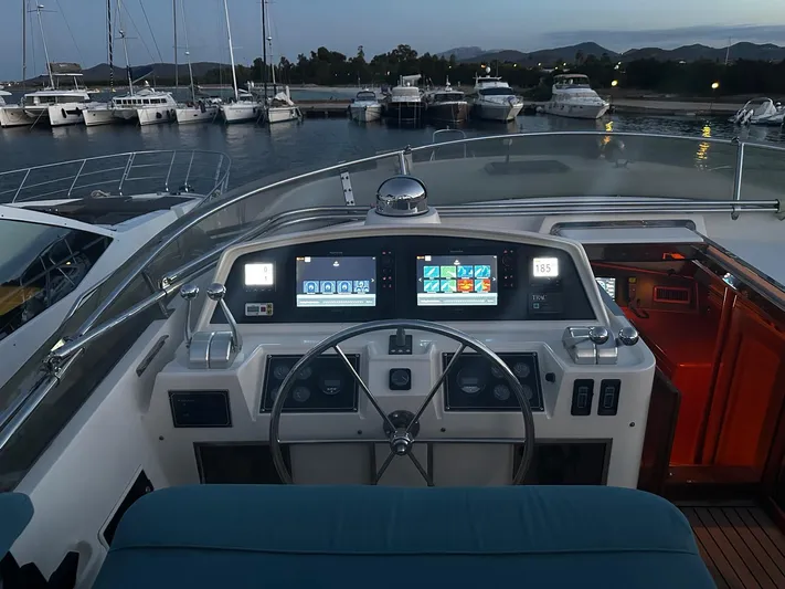 Smaragd Yacht Photos Pics Helm of 2003 Fleming 55 yacht with modern navigation displays at dusk in marina.