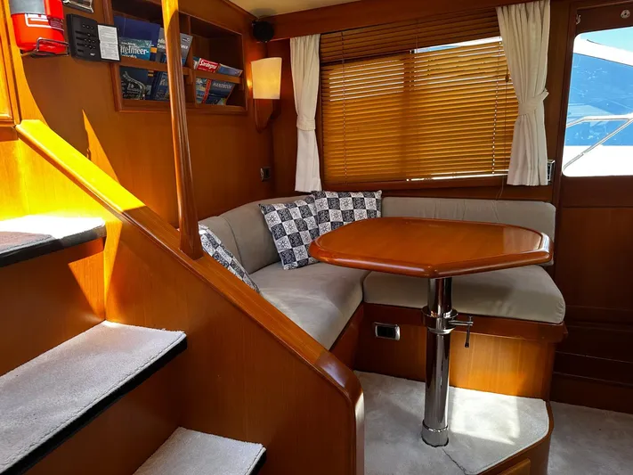 Smaragd Yacht Photos Pics Luxurious 2003 Fleming 55 yacht interior with cozy seating and wooden table.