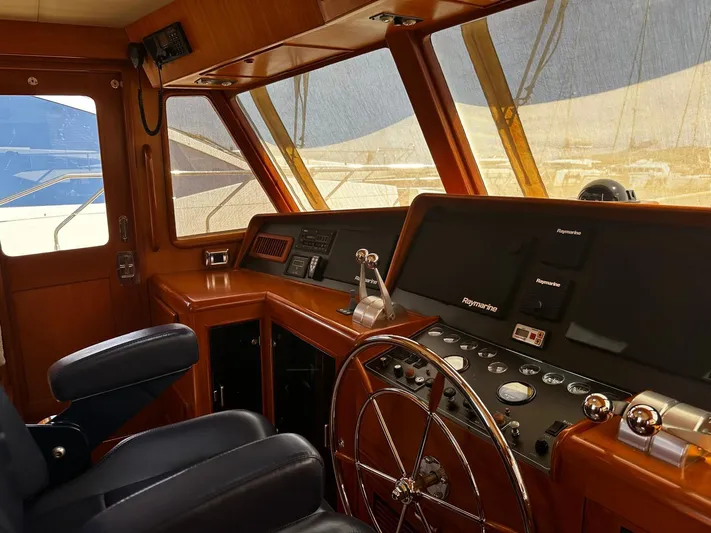 Smaragd Yacht Photos Pics Pilothouse interior of a 2003 Fleming 55 yacht with steering wheel and navigation controls.