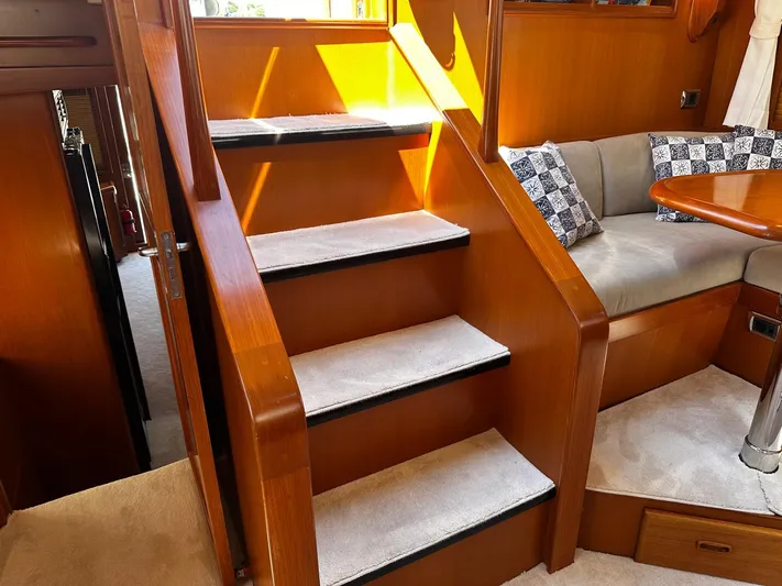 Smaragd Yacht Photos Pics Interior of 2003 Fleming 55 yacht with wooden stairs and cozy seating area.