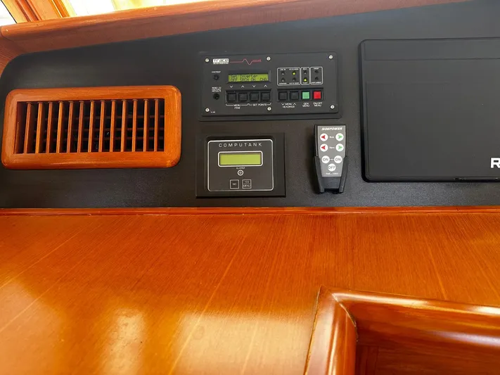 Smaragd Yacht Photos Pics Control panel of a 2003 Fleming 55 yacht with wood finish and electronic displays.