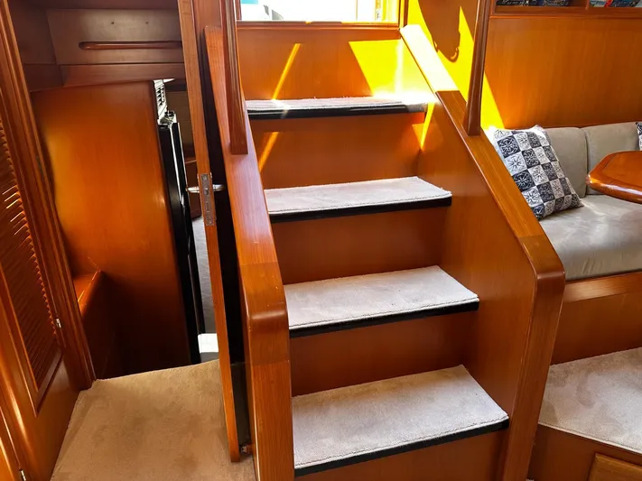 Smaragd Yacht Photos Pics Interior of 2003 Fleming 55 yacht with wooden stairs and cozy seating area.