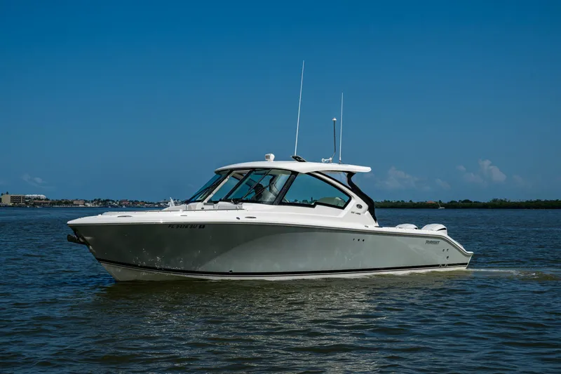  Yacht Photos Pics 2021 Pursuit DC 326 Dual Console boat cruising on calm waters under a clear blue sky.