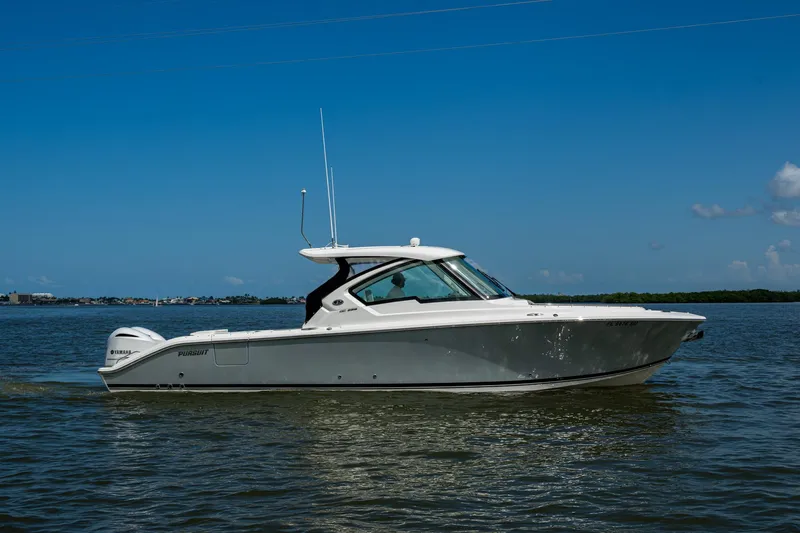  Yacht Photos Pics 2021 Pursuit DC 326 Dual Console boat on calm water under clear blue sky.