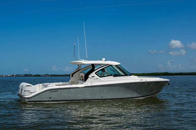 Yacht Photos Pics 2021 Pursuit DC 326 Dual Console boat on calm water under clear blue sky.