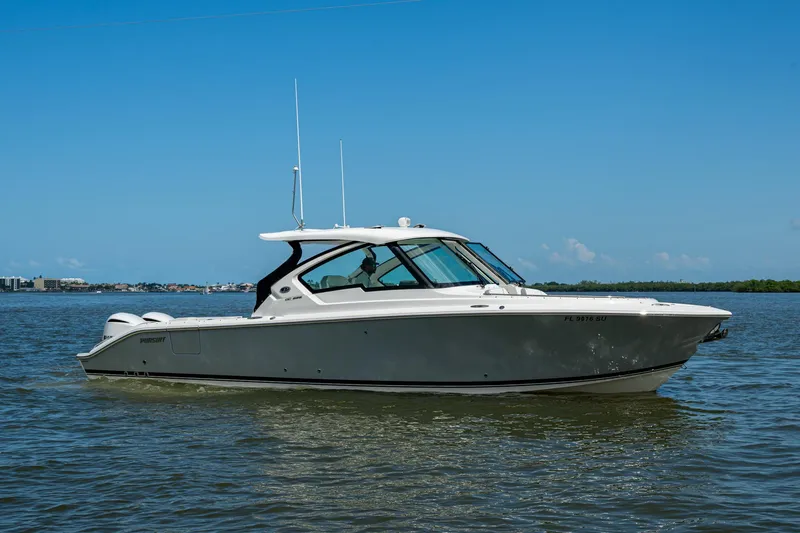  Yacht Photos Pics 2021 Pursuit DC 326 Dual Console boat on calm water under clear blue sky.