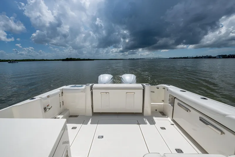  Yacht Photos Pics 2021 Pursuit DC 326 Dual Console boat on calm water under cloudy sky.