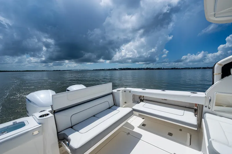  Yacht Photos Pics 2021 Pursuit DC 326 Dual Console boat on calm water under cloudy sky.