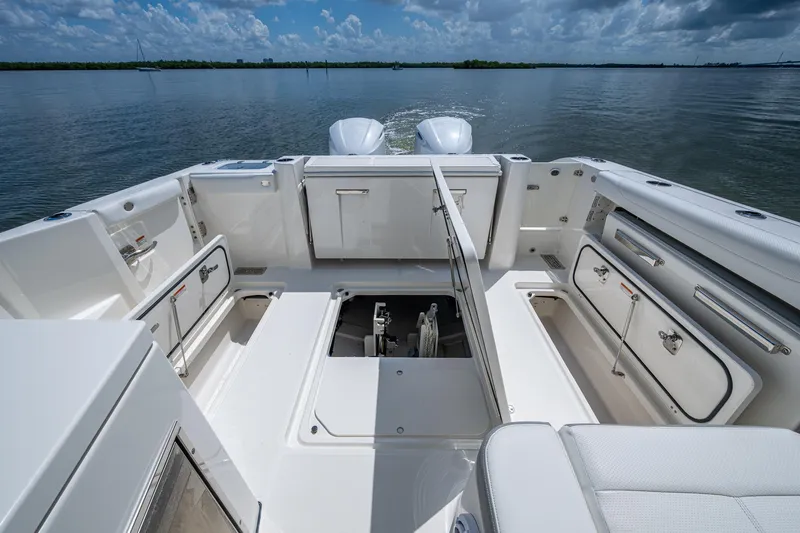  Yacht Photos Pics 2021 Pursuit DC 326 Dual Console boat interior with open storage compartments on calm water.