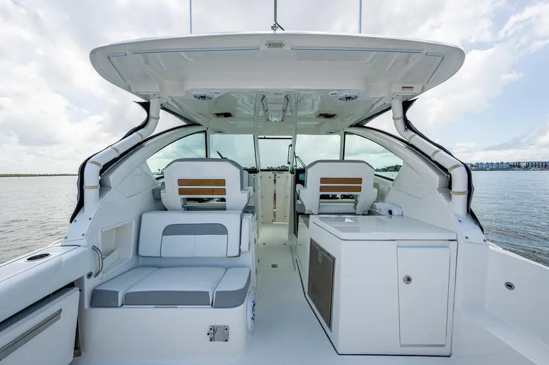  Yacht Photos Pics 2021 Pursuit DC 326 Dual Console boat interior with seating and storage, on calm water.