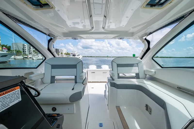  Yacht Photos Pics 2021 Pursuit DC 326 Dual Console interior with waterfront view, featuring modern seating and design.