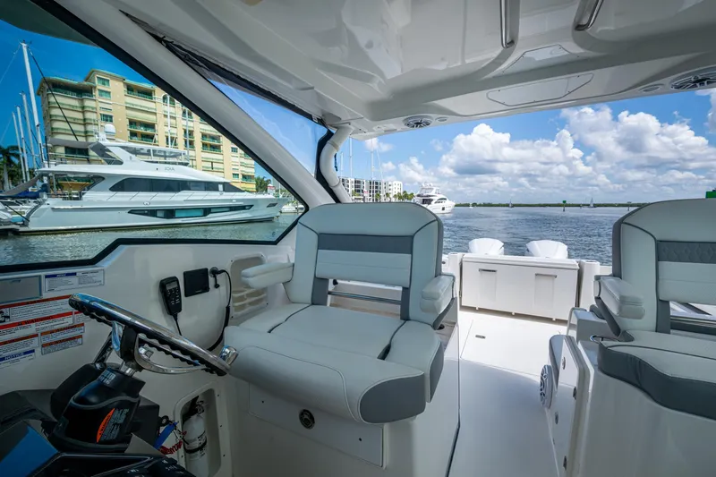  Yacht Photos Pics 2021 Pursuit DC 326 Dual Console interior with marina view, featuring modern seating and controls.