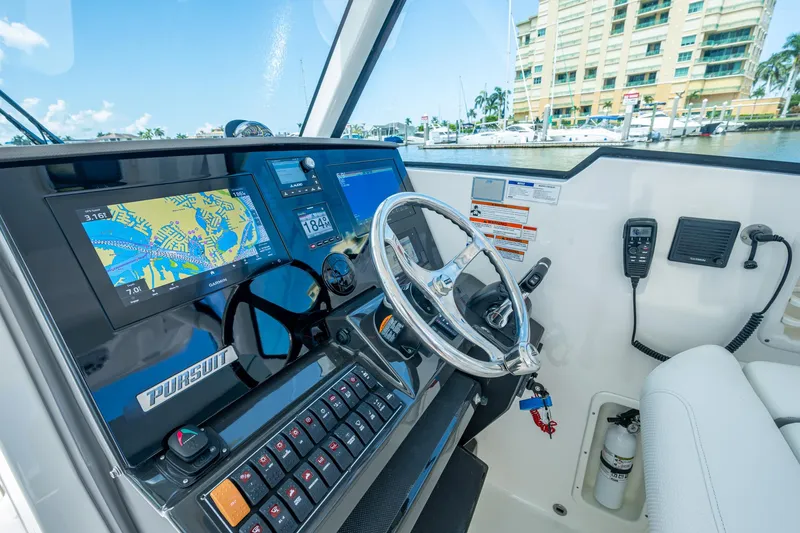  Yacht Photos Pics 2021 Pursuit DC 326 Dual Console boat dashboard with navigation screens and steering wheel.