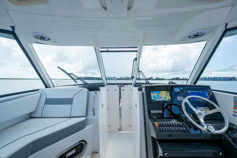  Yacht Photos Pics 2021 Pursuit DC 326 Dual Console interior with modern dashboard and seating, overlooking water.