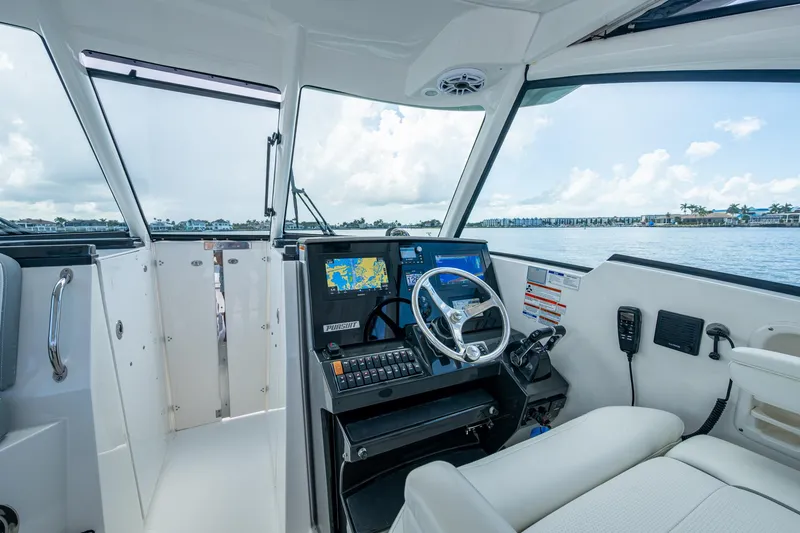  Yacht Photos Pics 2021 Pursuit DC 326 Dual Console boat interior with navigation system and steering wheel.