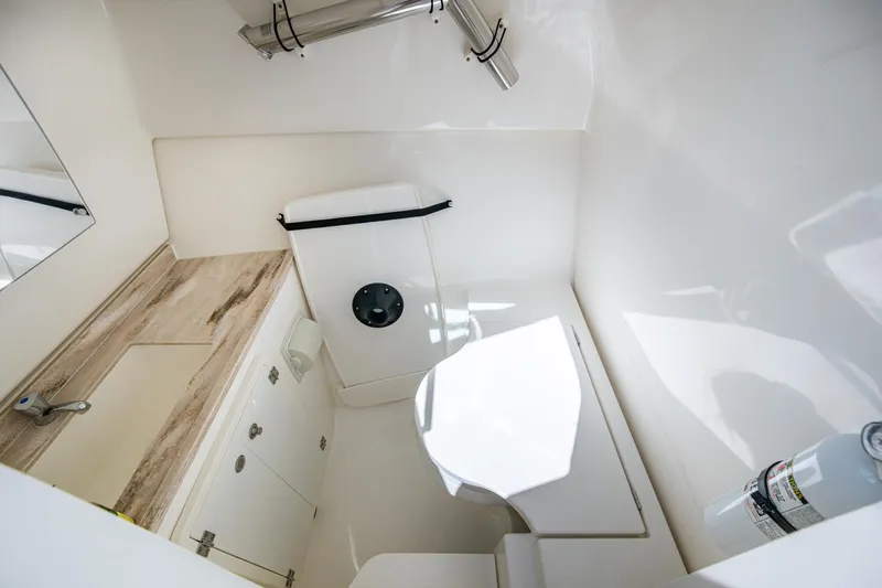  Yacht Photos Pics 2021 Pursuit DC 326 Dual Console boat bathroom with sink and storage.
