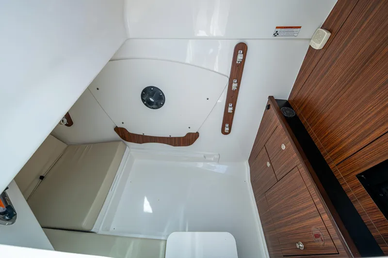  Yacht Photos Pics 2021 Pursuit DC 326 Dual Console cabin interior with wood accents and seating area.