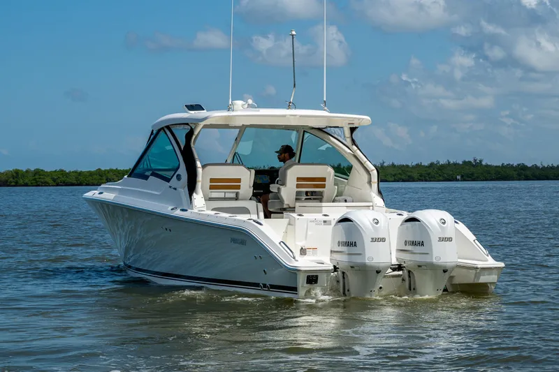  Yacht Photos Pics 2021 Pursuit DC 326 Dual Console boat cruising on calm water with twin Yamaha engines.