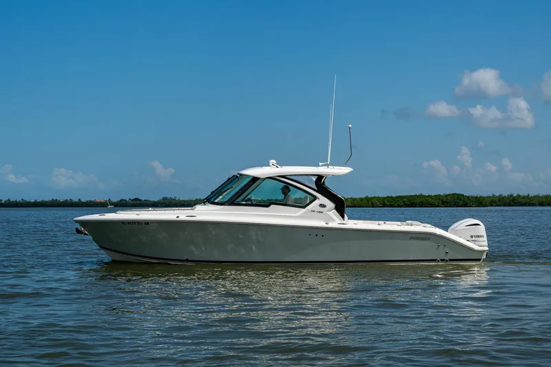  Yacht Photos Pics 2021 Pursuit DC 326 Dual Console boat on calm water under clear blue sky.