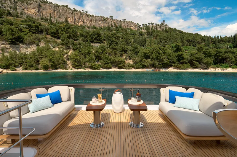  Yacht Photos Pics Luxurious 2022 Azimut 78 yacht deck with elegant seating, overlooking serene waters and lush greenery.