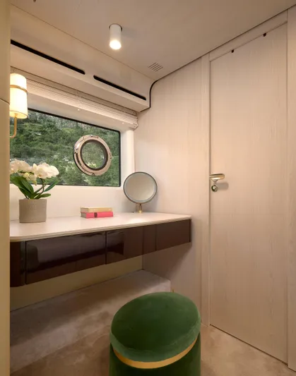 Yacht Photos Pics Luxurious interior of 2022 Azimut 78 yacht with vanity, green stool, and porthole window.