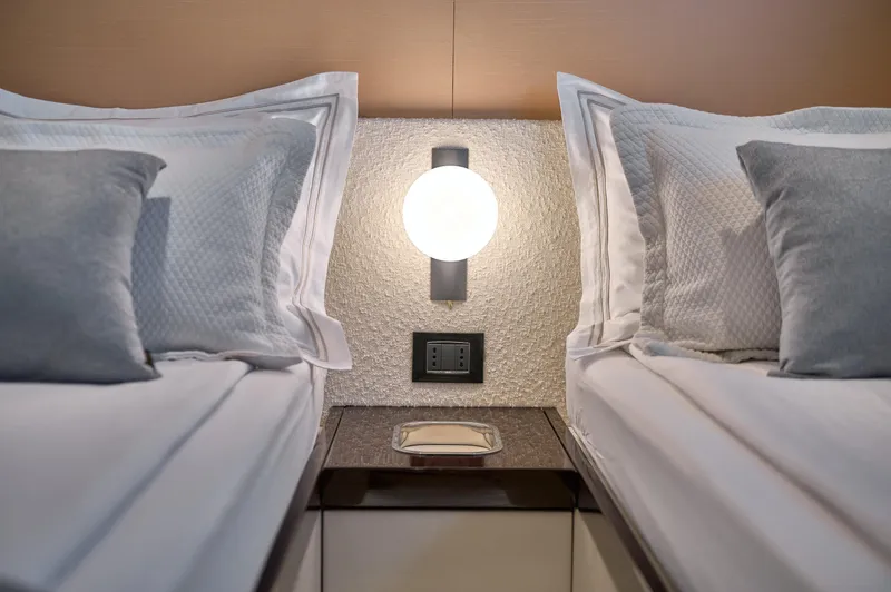  Yacht Photos Pics Luxurious twin beds in 2022 Azimut 78 yacht cabin, featuring elegant bedding and modern lighting.