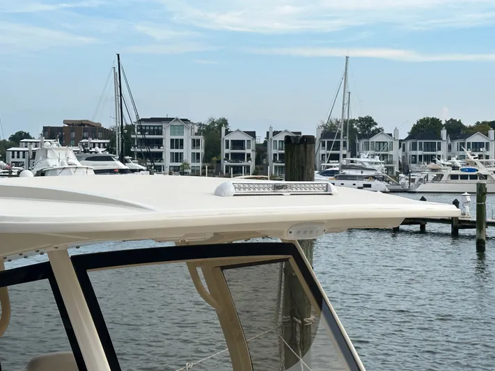  Yacht Photos Pics 2024 Scout 277 LXF boat docked with modern buildings in background.
