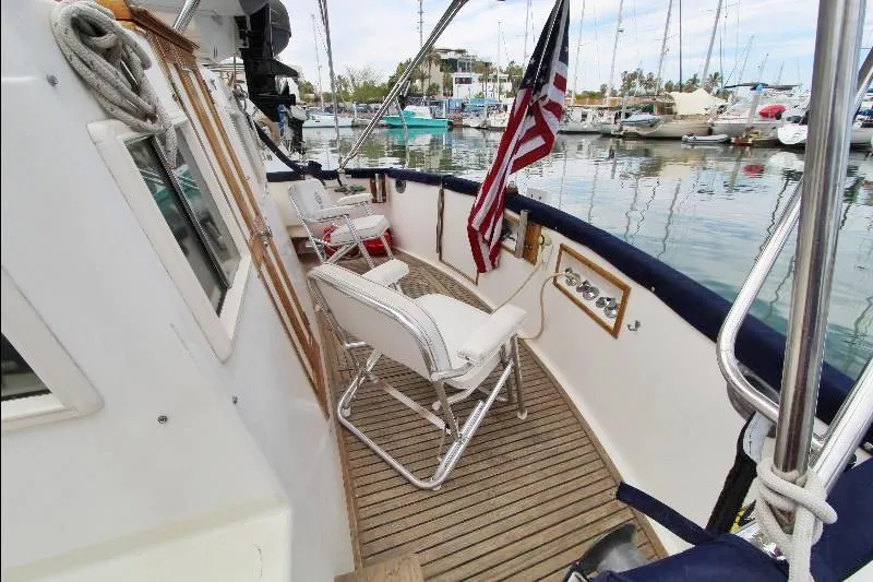  Yacht Photos Pics 1989 Grand Banks Classic yacht deck with seating, American flag, and marina view.