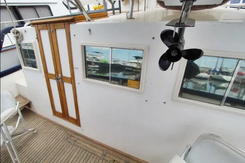  Yacht Photos Pics 1989 Grand Banks Classic yacht deck with wooden doors and windows, showcasing marina reflections.