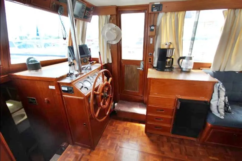  Yacht Photos Pics 1989 Grand Banks Classic boat interior with wooden helm, navigation equipment, and cozy seating area.