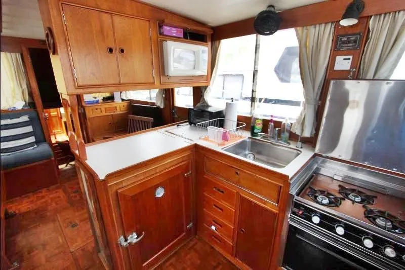  Yacht Photos Pics 1989 Grand Banks Classic yacht kitchen with wooden cabinetry, stove, and sink.