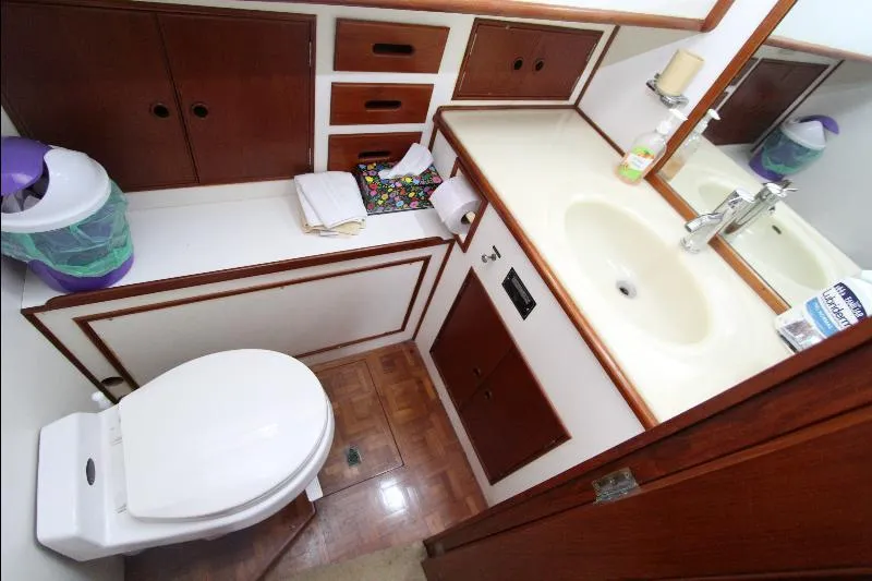  Yacht Photos Pics 1989 Grand Banks Classic yacht bathroom with sink, toilet, and wooden cabinetry.