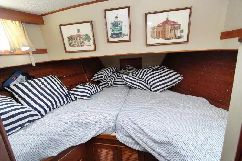  Yacht Photos Pics Cozy cabin interior of 1989 Grand Banks Classic with striped bedding and framed artwork.