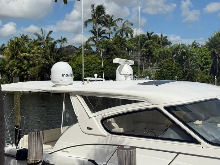 Shelly Anne Yacht Photos Pics 2000 Tiara Yachts 5200 Express docked, featuring Garmin and Intellian equipment, surrounded by lush greenery.