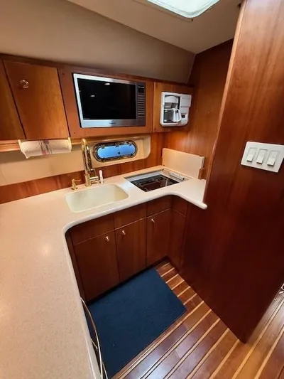 Shelly Anne Yacht Photos Pics 2000 Tiara Yachts 5200 Express kitchen with wood cabinetry, sink, and microwave.