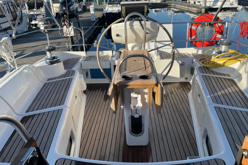 "dragonfly" Yacht Photos Pics Cockpit of 2003 Jeanneau Sun Odyssey 43 DS sailboat with wooden deck and steering wheel.