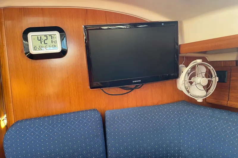 "dragonfly" Yacht Photos Pics Interior of 2003 Jeanneau Sun Odyssey 43 DS with TV, clock, and fan.